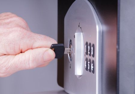 Insérer une clé dans une serrure de coffre-fort à combinaison argentée