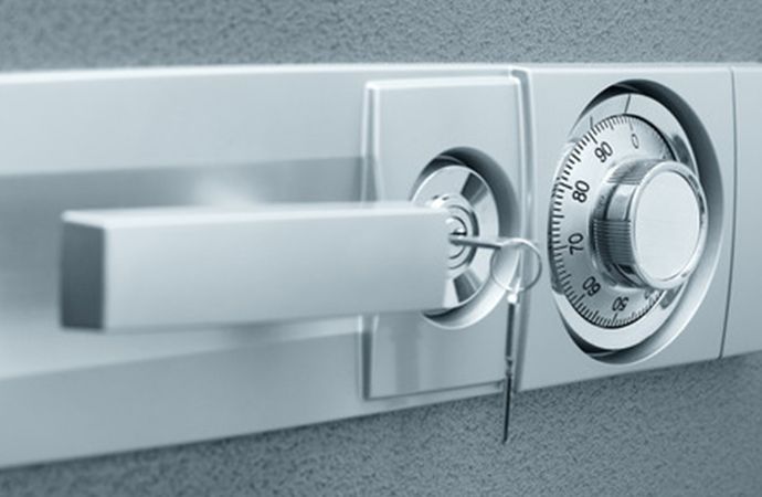 Serrure de porte argentée avec clé insérée et cadran à combinaison sur un coffre-fort ou une boîte de sécurité