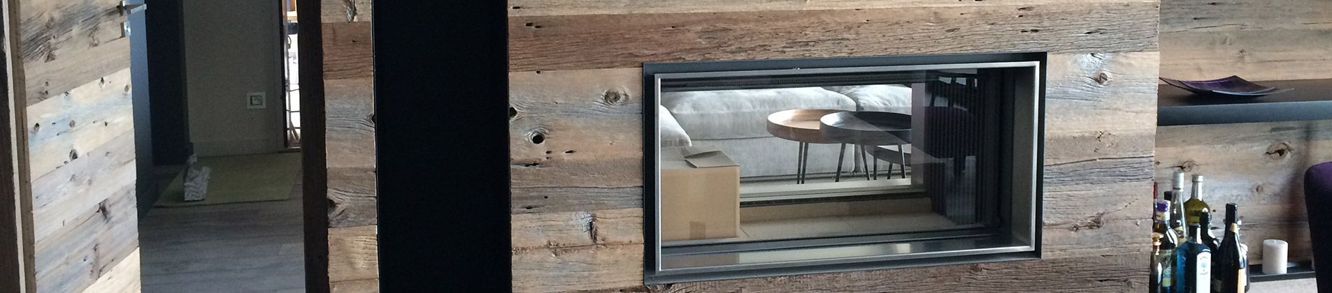 Cheminée moderne avec mur lambrissé et étagères à bûches dans une pièce contemporaine
