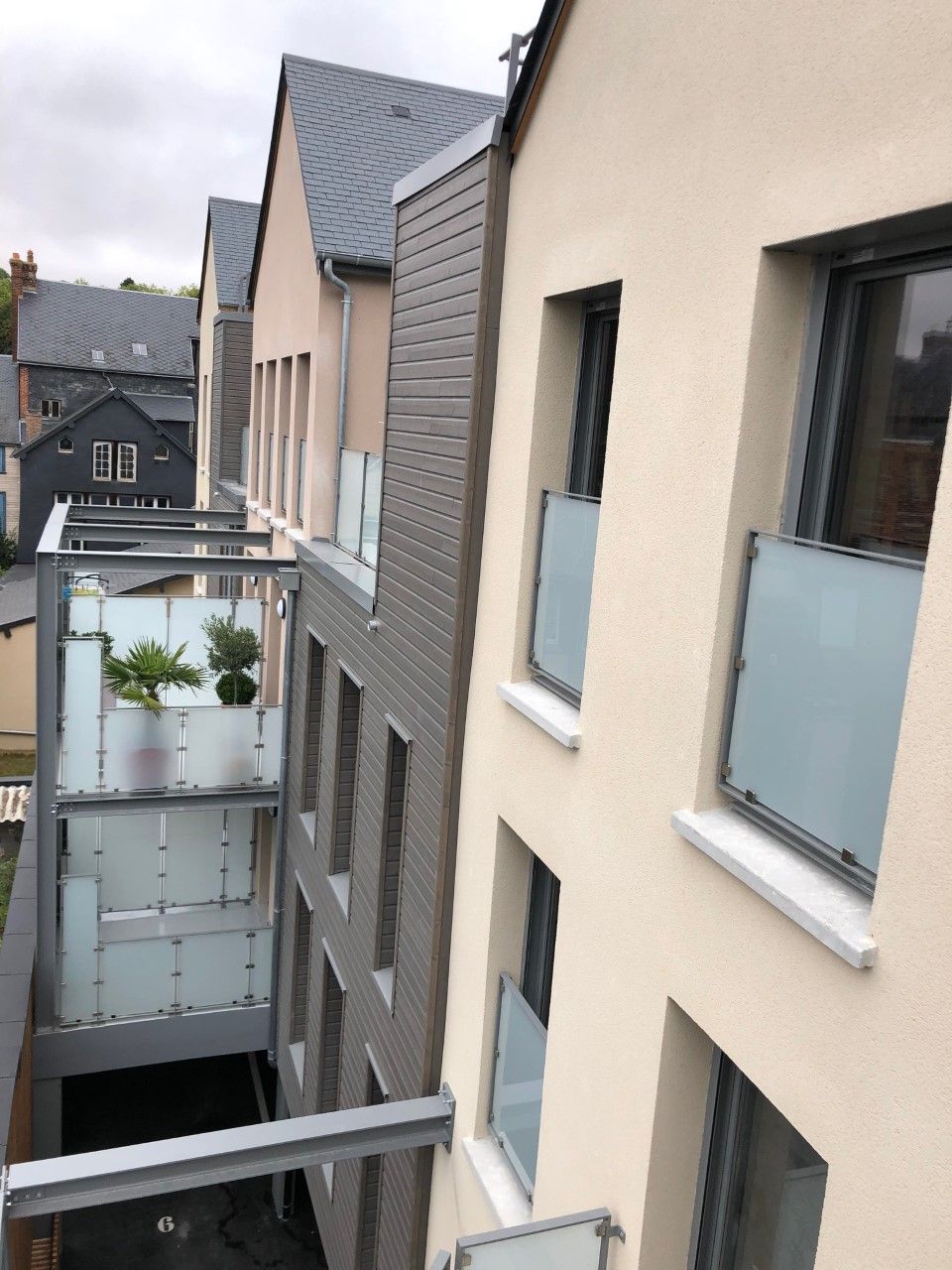 Balcons et fenêtres d'un immeuble d'appartements moderne donnant sur une cour étroite