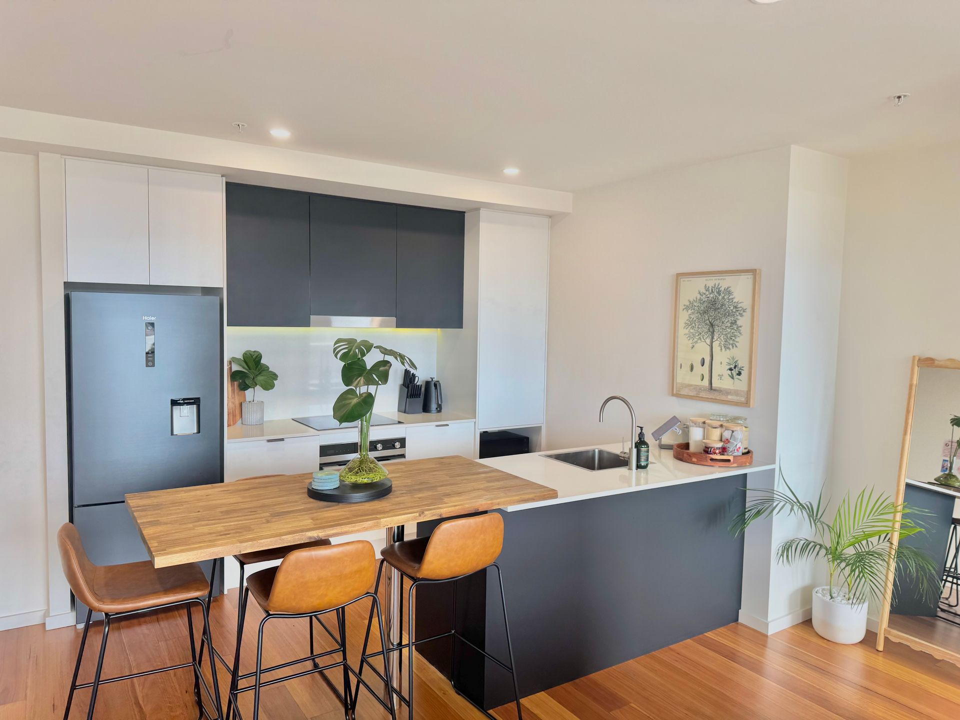 Modern kitchen with dark cabinets, a wood-topped breakfast bar.