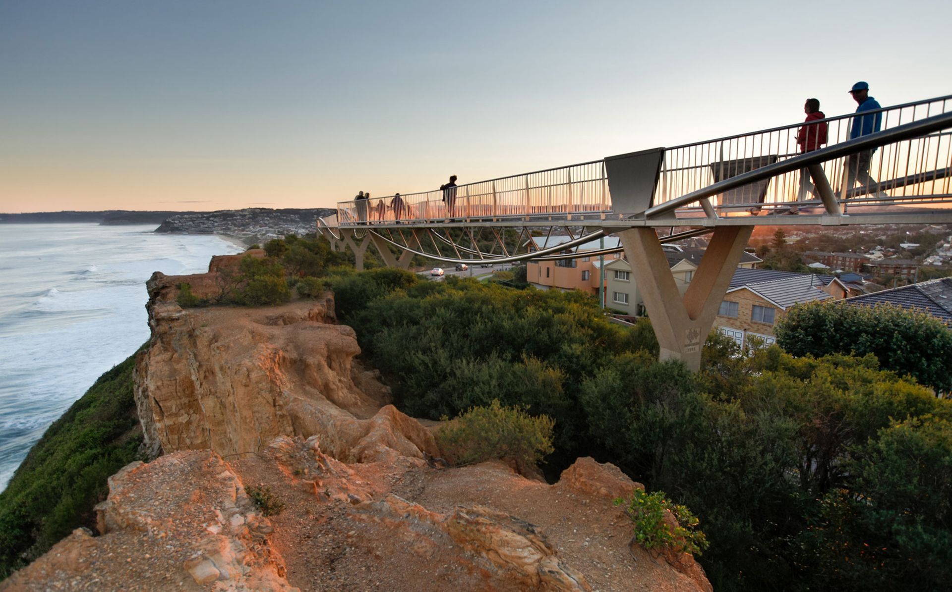 Cliffside walkway with people overlooking the ocean at sunset. Newcastle NSW