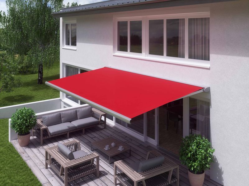 Rote, einziehbare Markise über einer Terrasse mit Sitzgelegenheiten; weißes Gebäude.