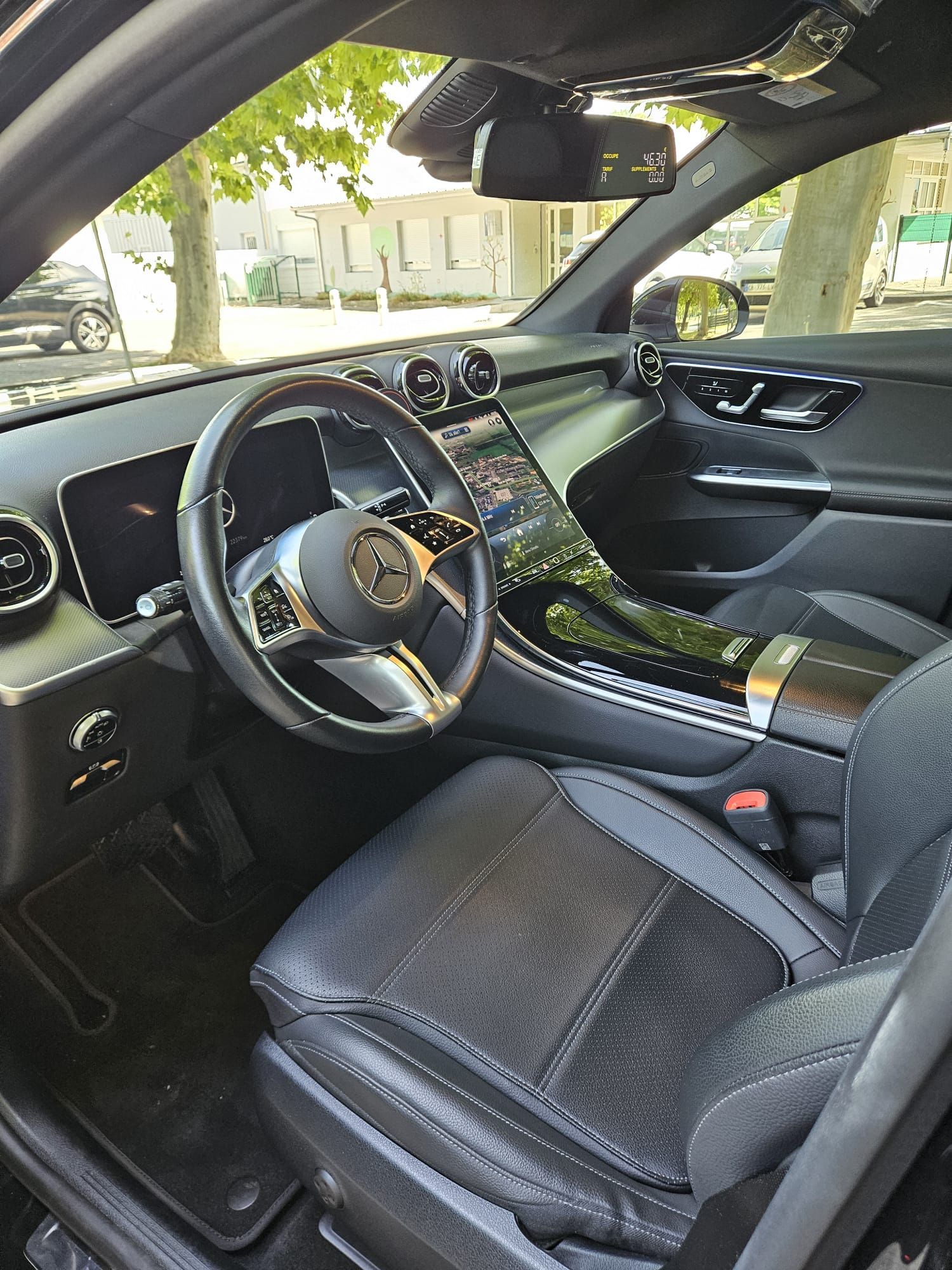 Intérieur de voiture de luxe avec sièges en cuir noir, garnitures dorées et vue du volant côté conducteur