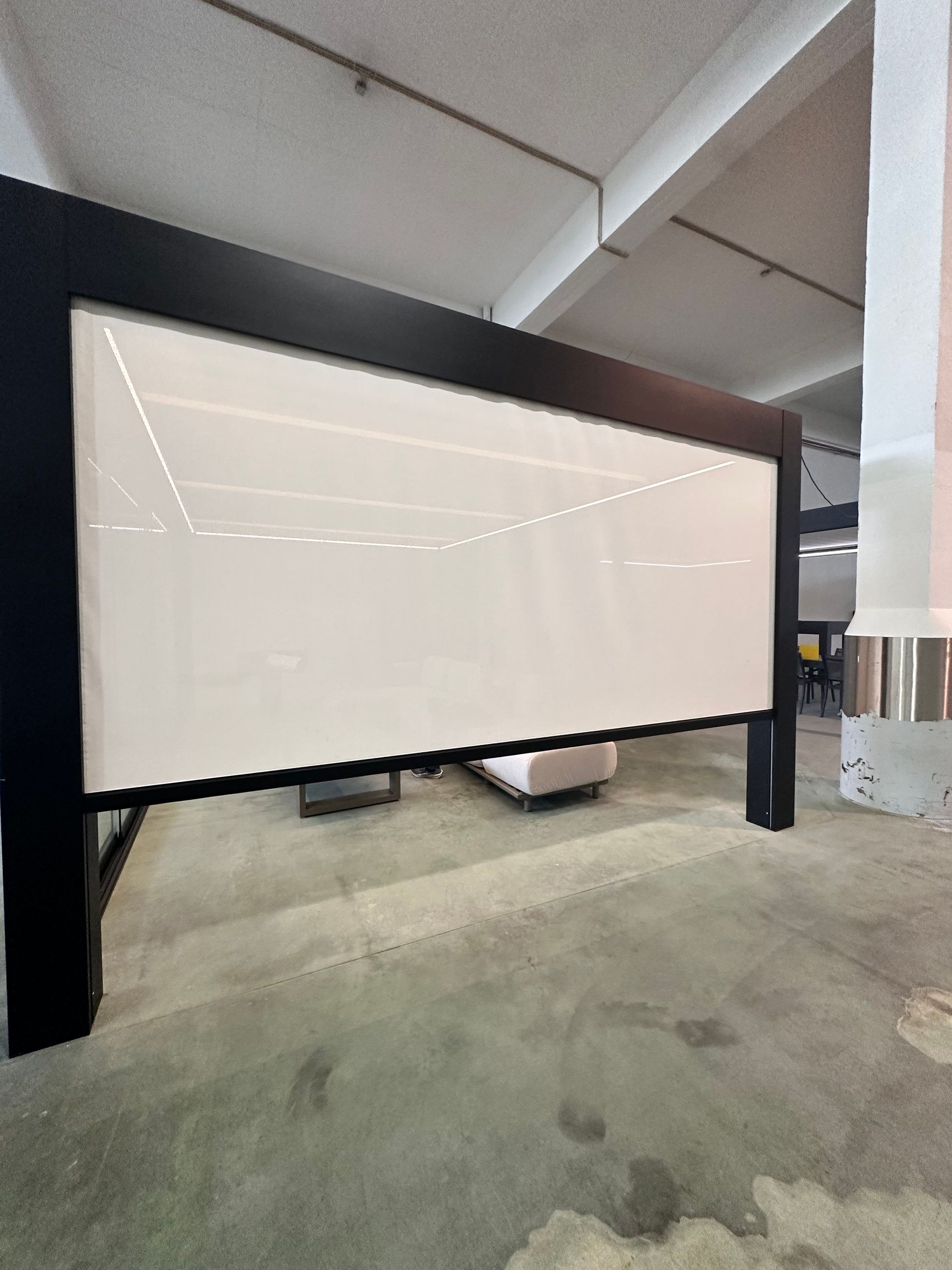 Tableau blanc à cadre noir dans un environnement industriel.