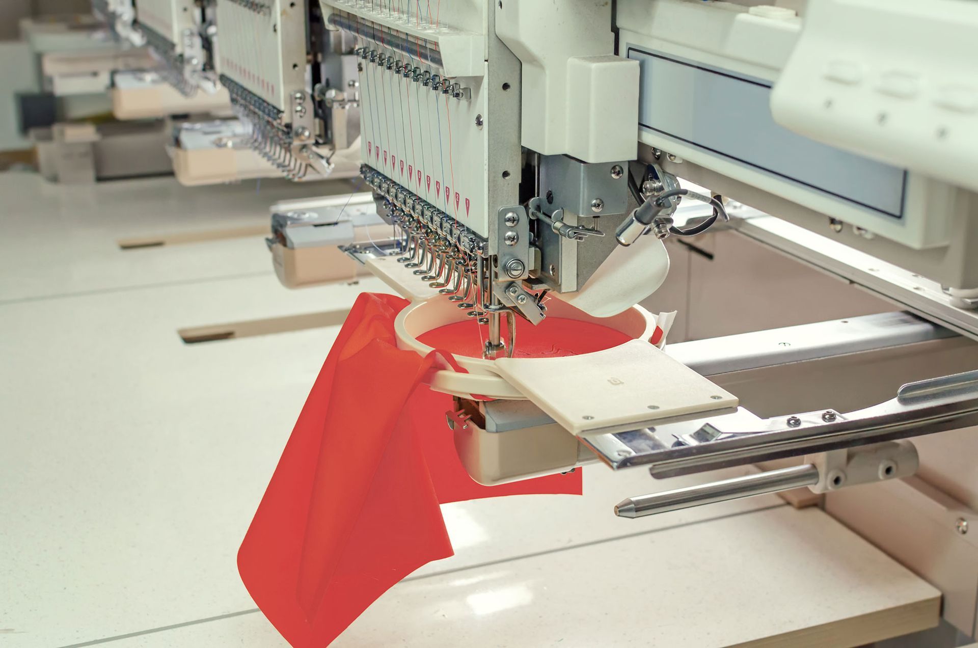 Stickmaschine näht roten Stoff.