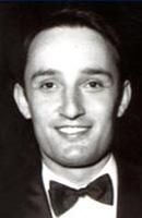 Lächelnder Mann mit Fliege und Anzugjacke, Schwarz-Weiß-Porträt.