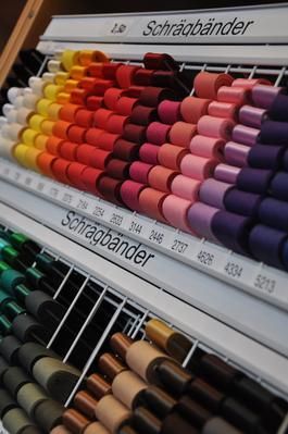 Reihen bunter Schrägbänder in einer Ladenauslage.