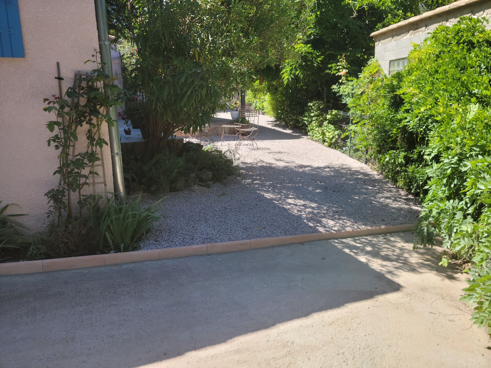 Un extérieur de maison en gravier avec des arbres