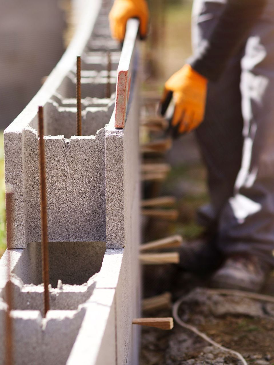 Un maçon qui réalise la pose d'un muret