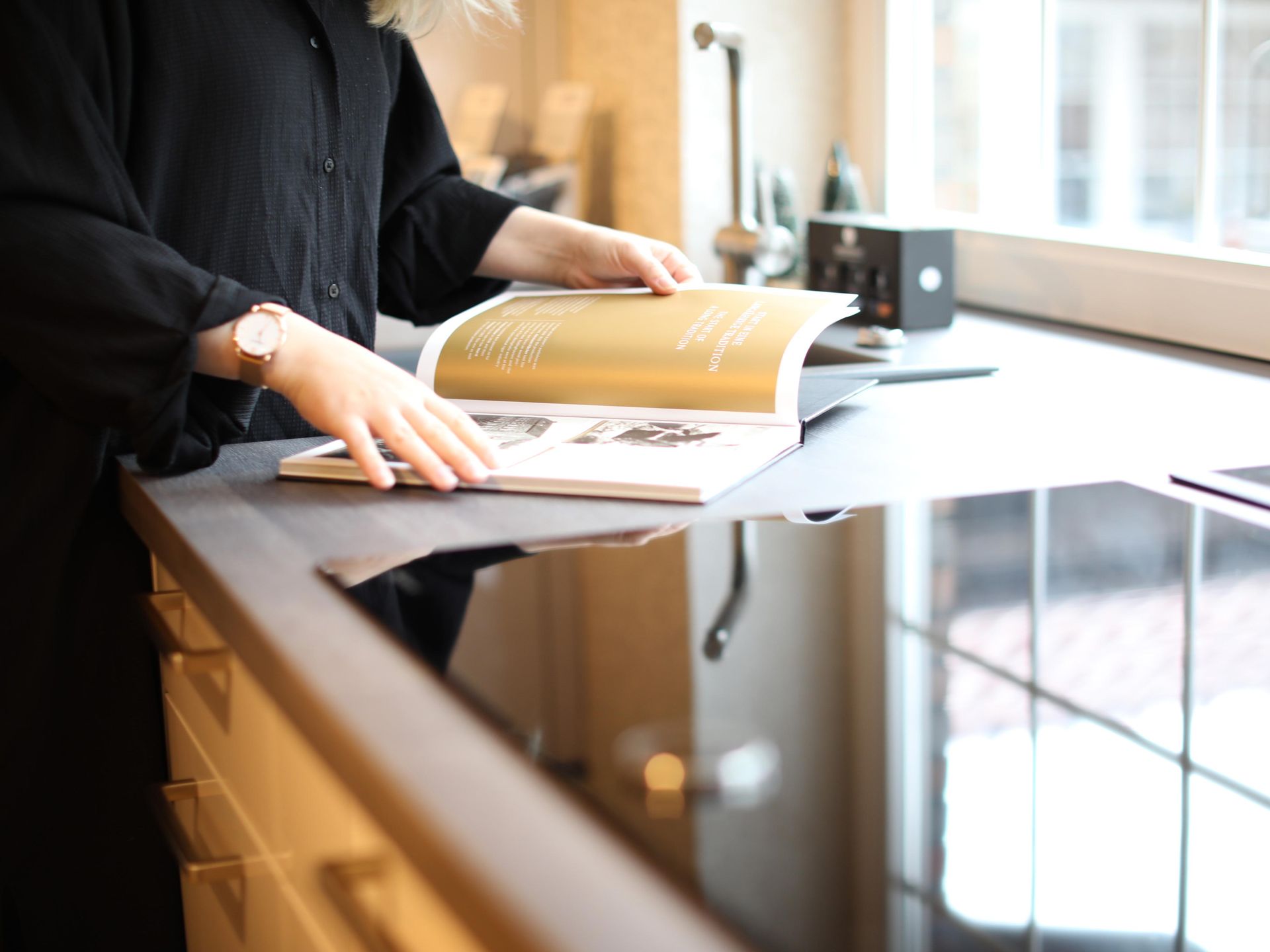 Eine Frau liest ein Buch auf einer Küchentheke