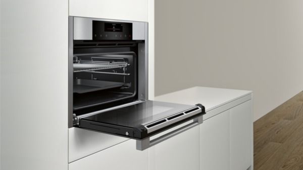ein Edelstahlbackofen mit der Tür offen in einer Küche