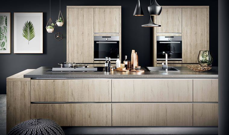 eine Küche mit Holzschränken , Edelstahlgeräten und einem Waschbecken