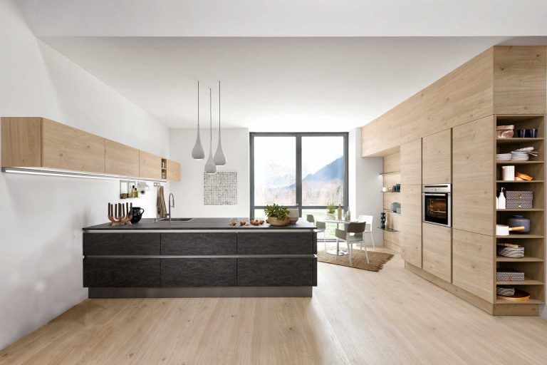 eine Küche mit Holzschränken und einem großen Fenster