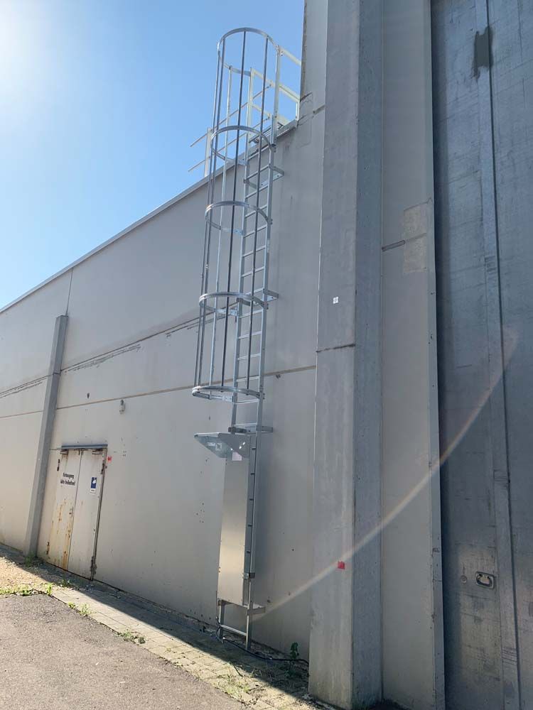 An der Seite eines Gebäudes ist eine Metallleiter angebracht.