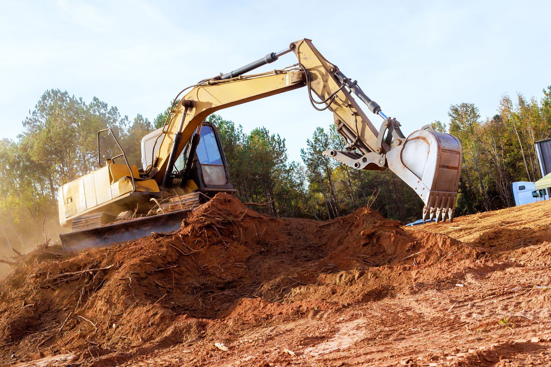 Una excavadora está moviendo tierra en un sitio de construcción.