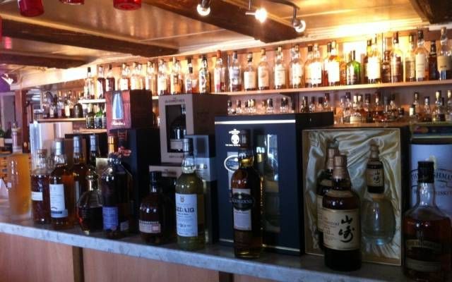 De nombreuses bouteilles d'alcool sont alignées sur un bar