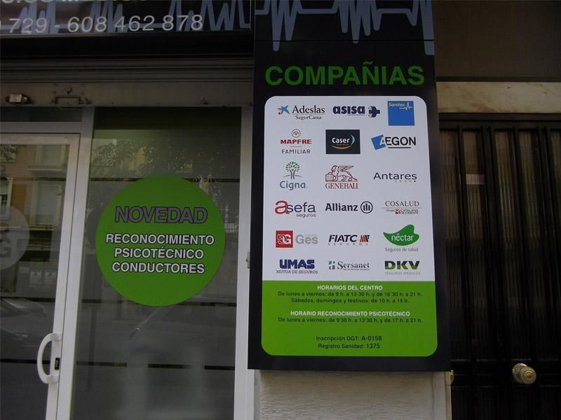 Storefront with green Spanish signs listing companies and “reconocimiento conductores particulares y colectivos”