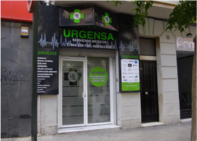 Fachada del centro médico URGENSA con puertas de cristal, letrero verde y lista de servicios en el exterior.
