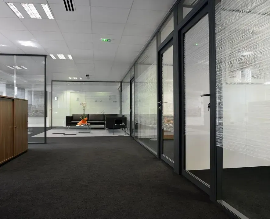 Bureaux avec moquette grise et cloisons de séparation vitrées