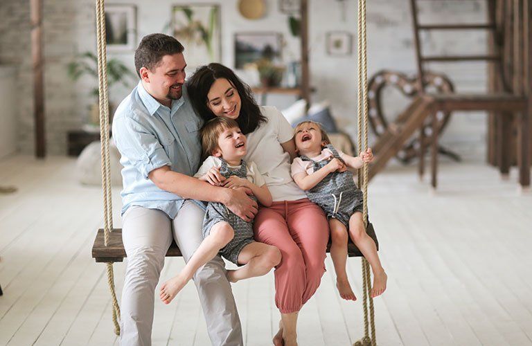 Couple et leurs deux enfants sur une balançoire