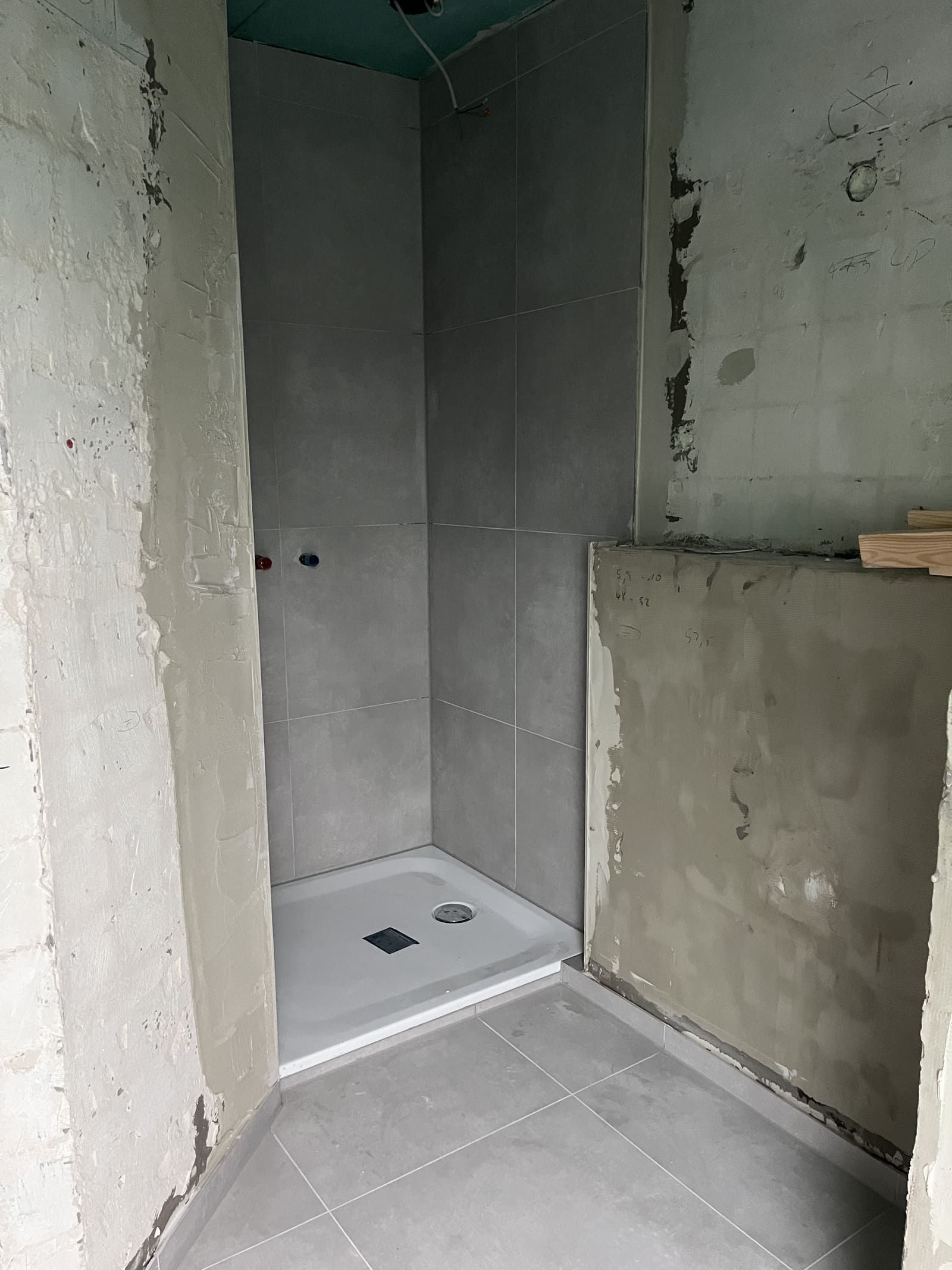 Ein im Bau befindliches Badezimmer mit ebenerdiger Dusche.