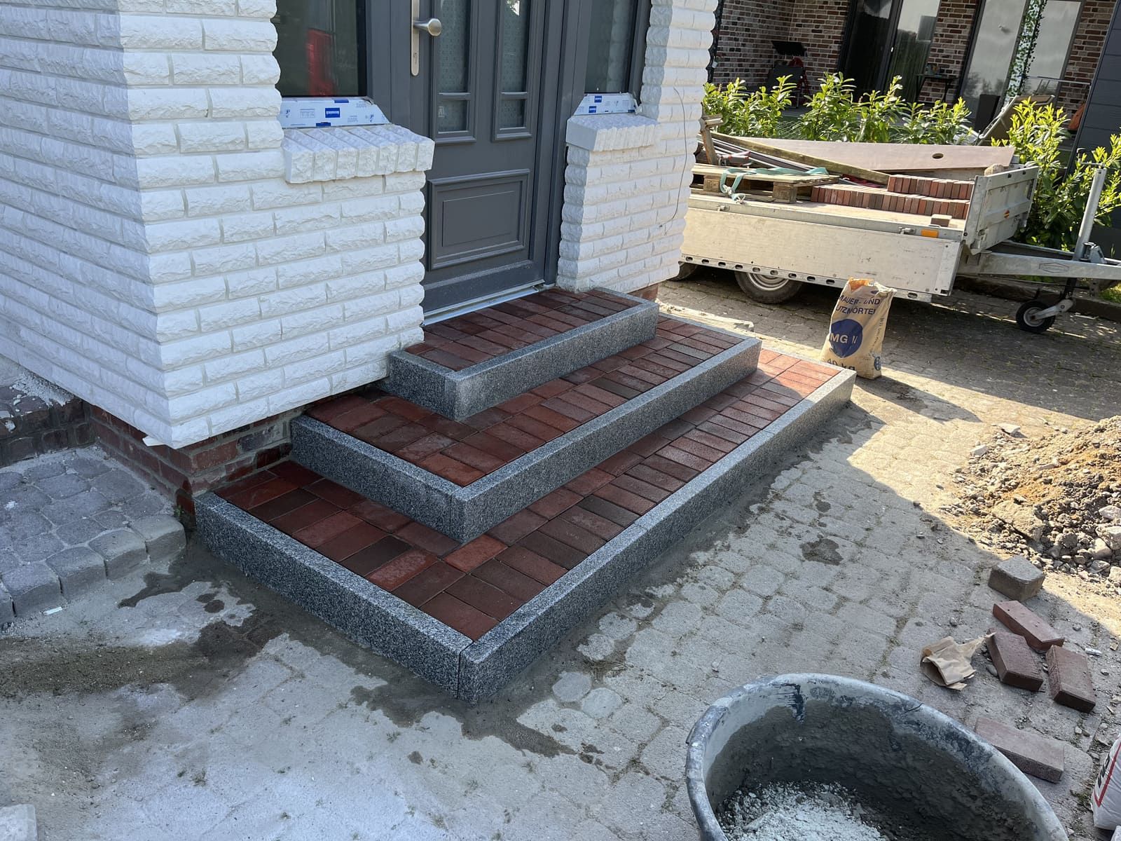 Vor einem Haus wird ein Ziegelweg gebaut.