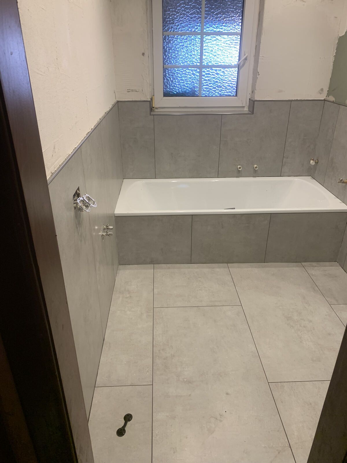 Ein Badezimmer mit Badewanne und Fenster.