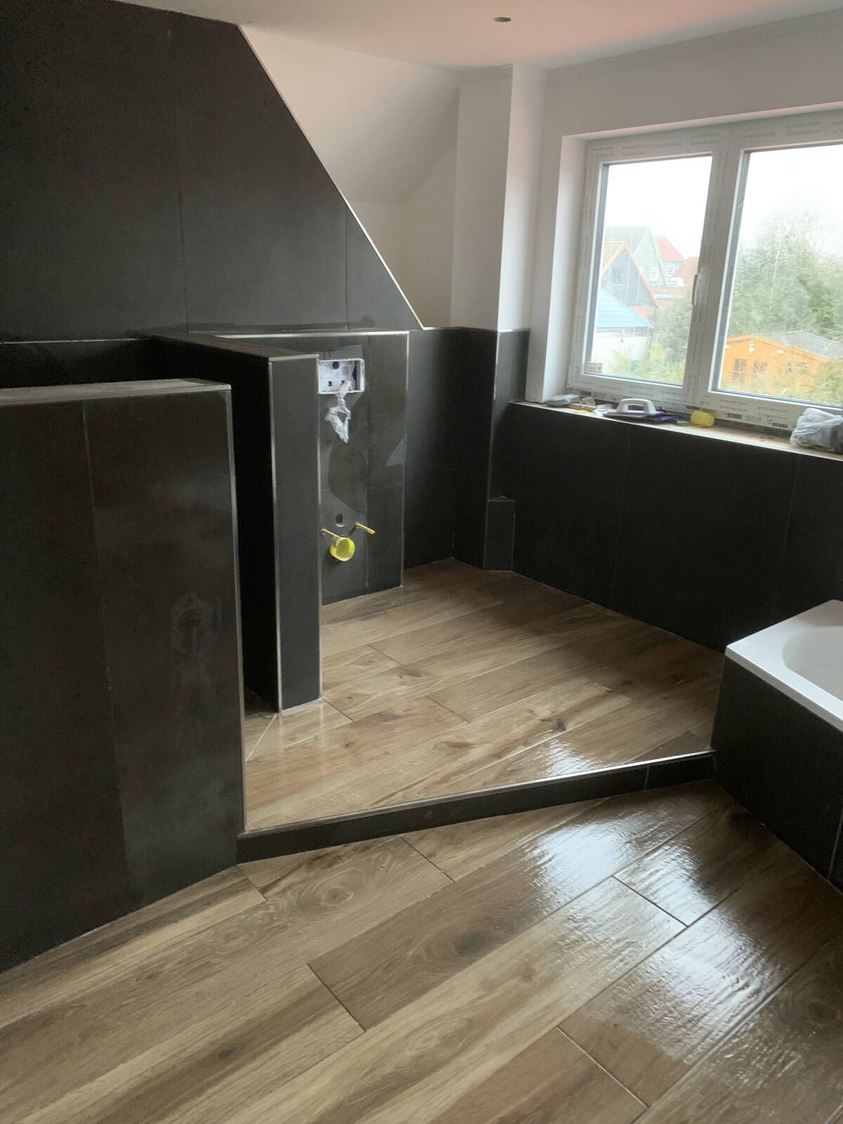 Ein Badezimmer mit Holzboden und Fenster