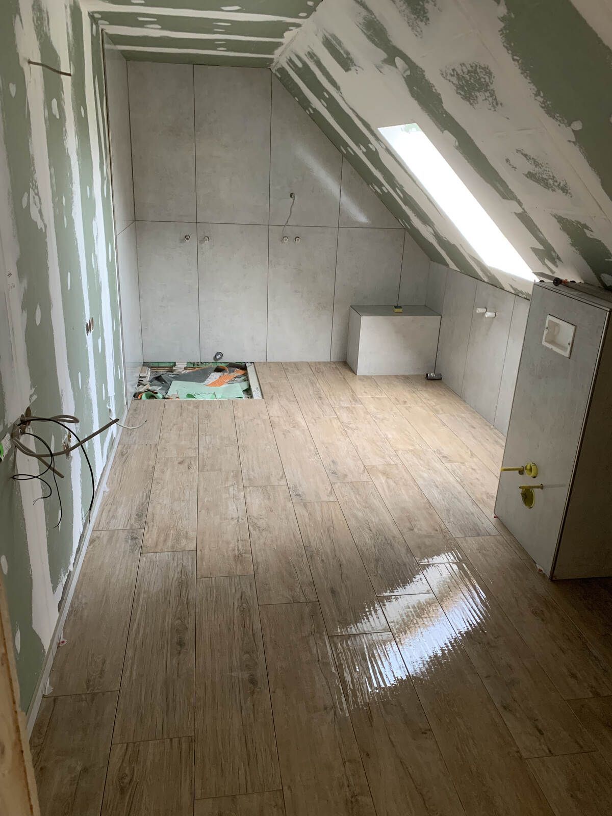 Ein Raum mit Holzboden und einem Oberlicht in der Decke.