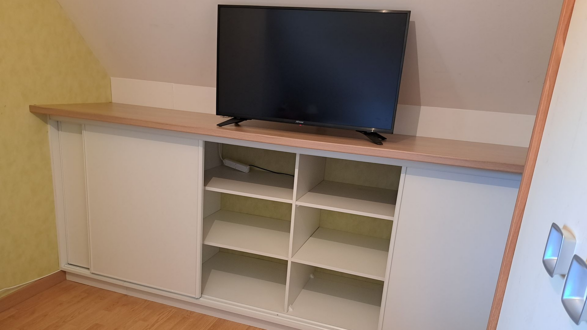 Artisan installant une étagère dans un meuble de rangement