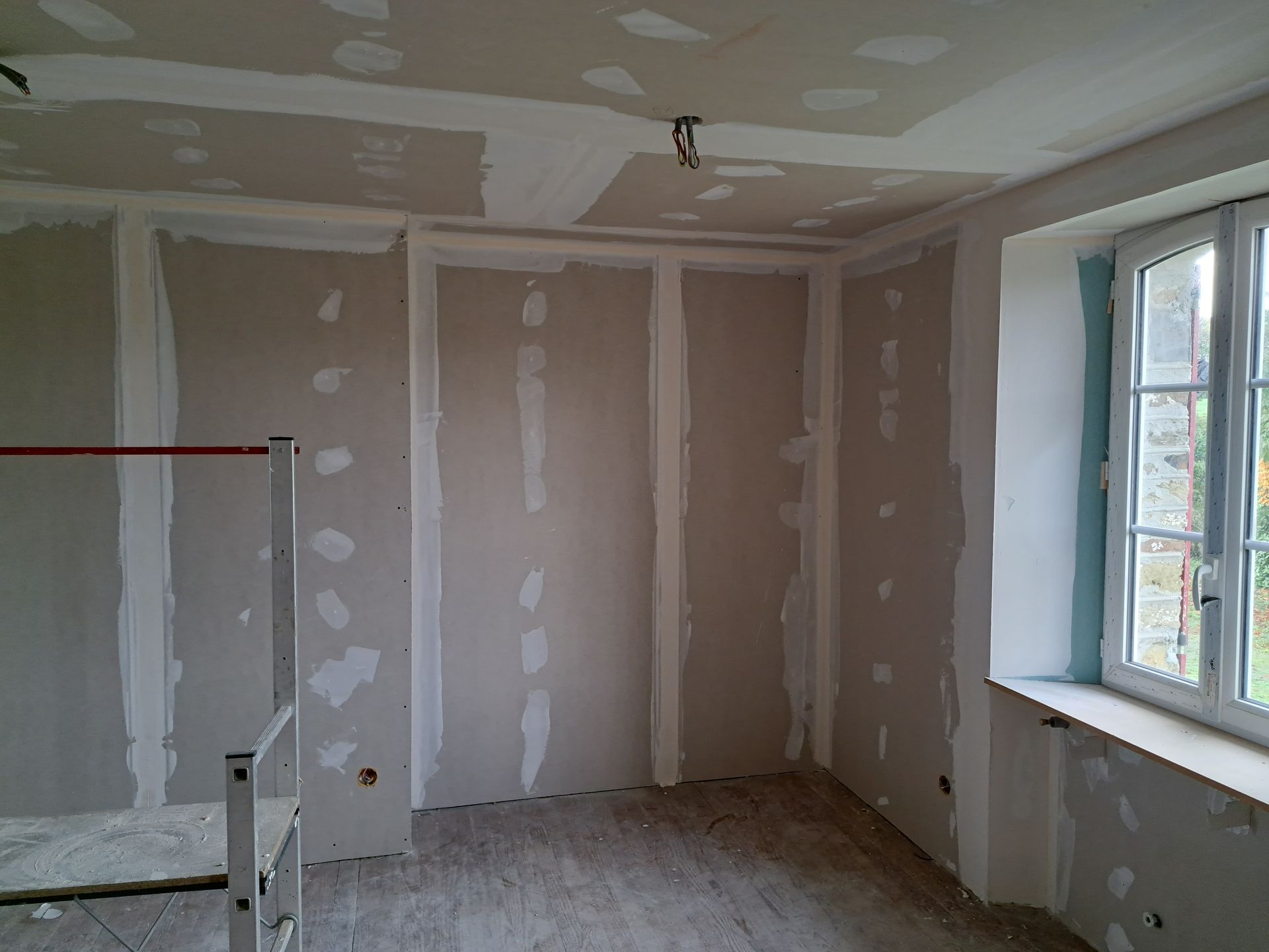 Pièce en cours d'aménagement avec des murs et sols préparés