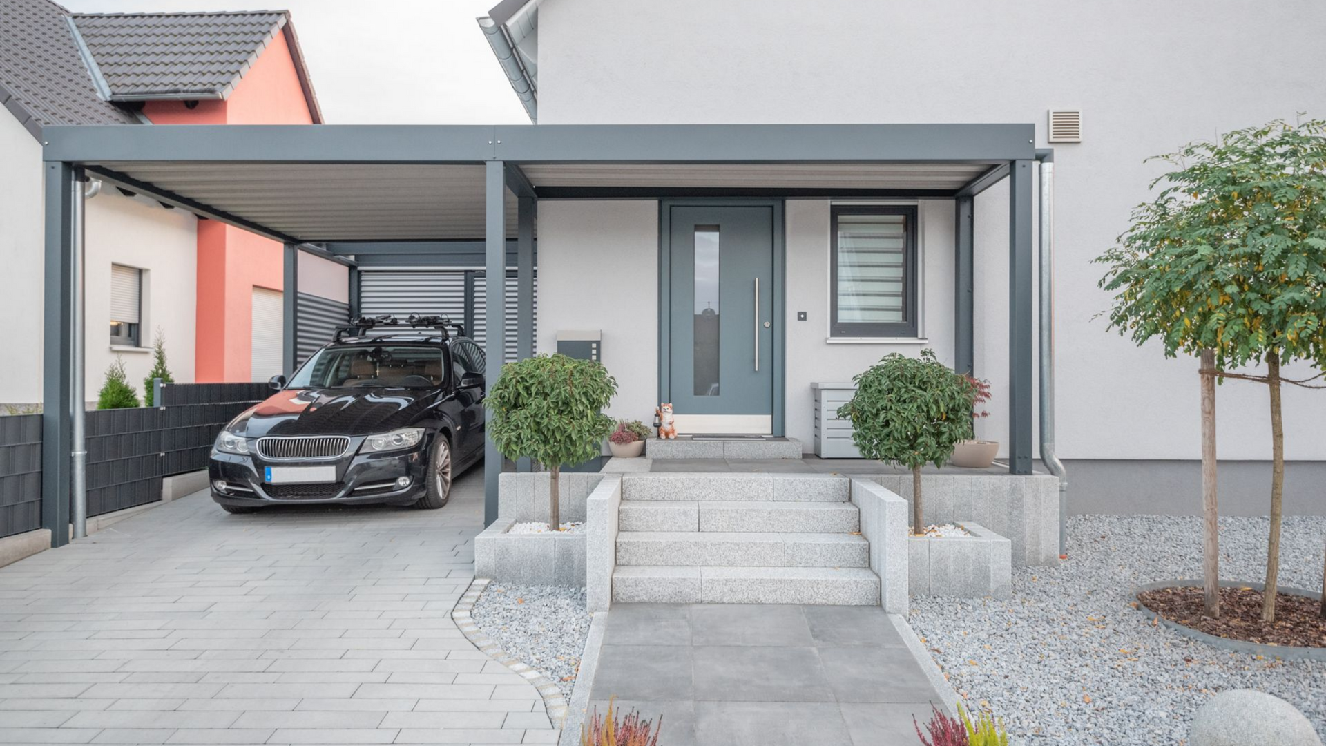 Maison avec carport abritant une voiture