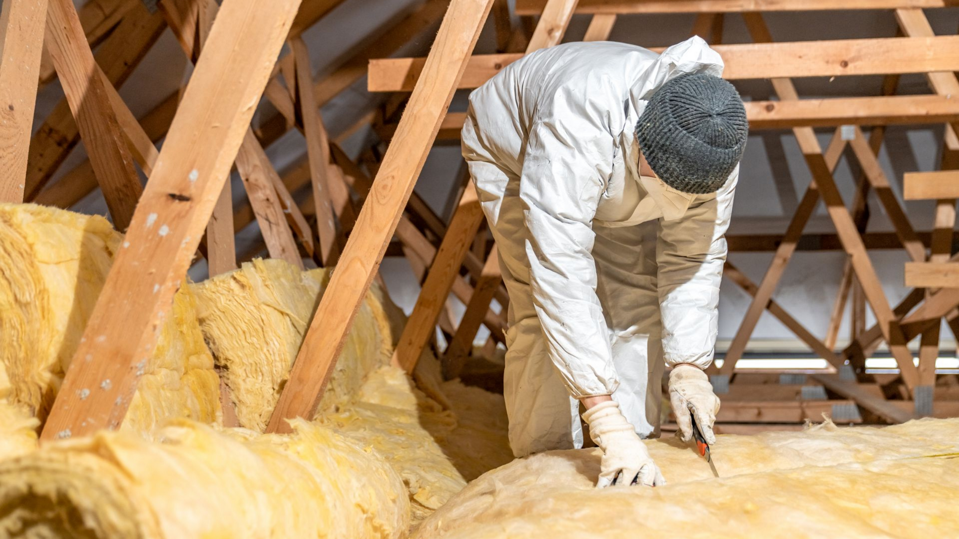 Artisan installant de l'isolation dans des combles