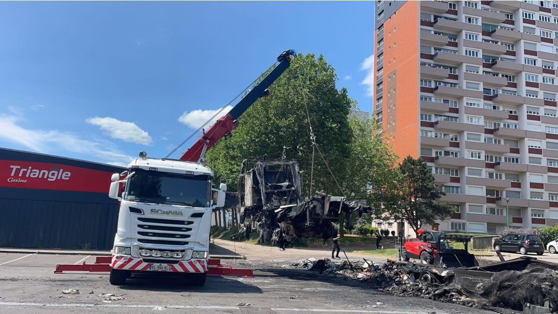 Désencombrement de la chaussée d'une épave de véhicule brulée par un camion-grue