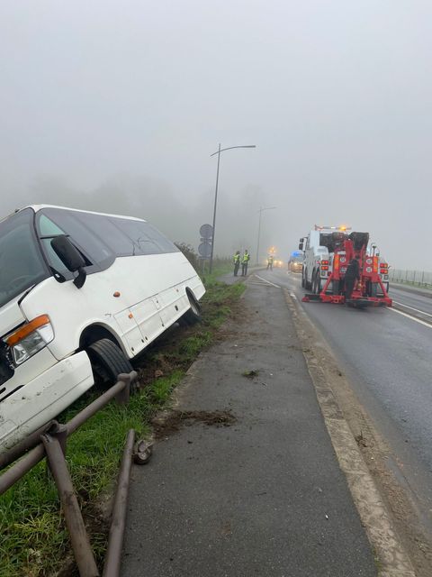 Un camion-grue relevant un autocar retourné sur la chaussée