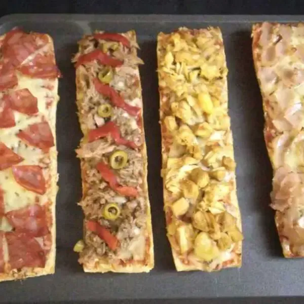 Cuatro pizzas largas y finas con diversos ingredientes, pepperoni, atún y aceitunas, pollo y jamón