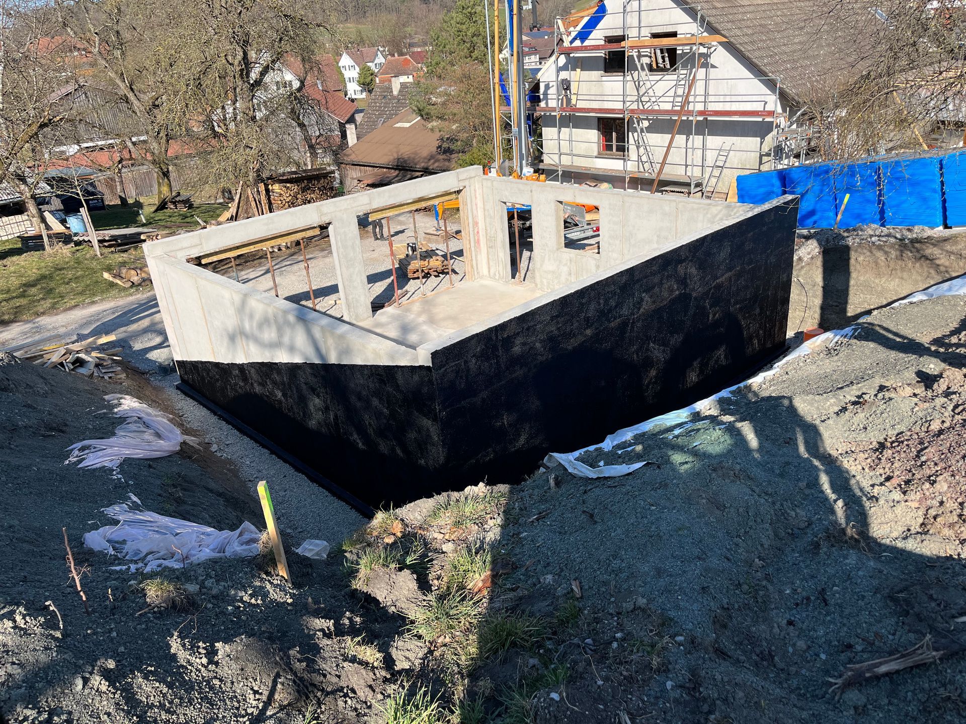 Auf einem Erdhügel wird eine große Betonkonstruktion errichtet.