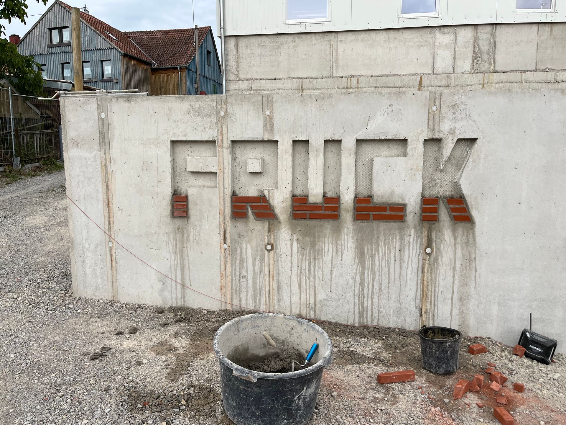 Eine Betonwand mit der Aufschrift „Fruck“