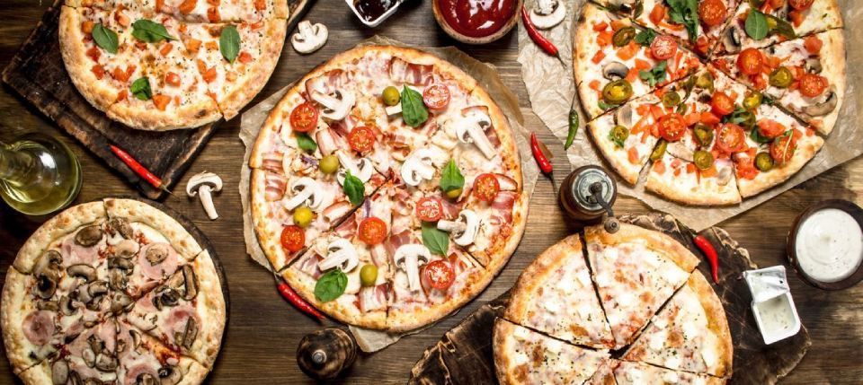 vue sur une table avec 5 pizzas de différentes sortes