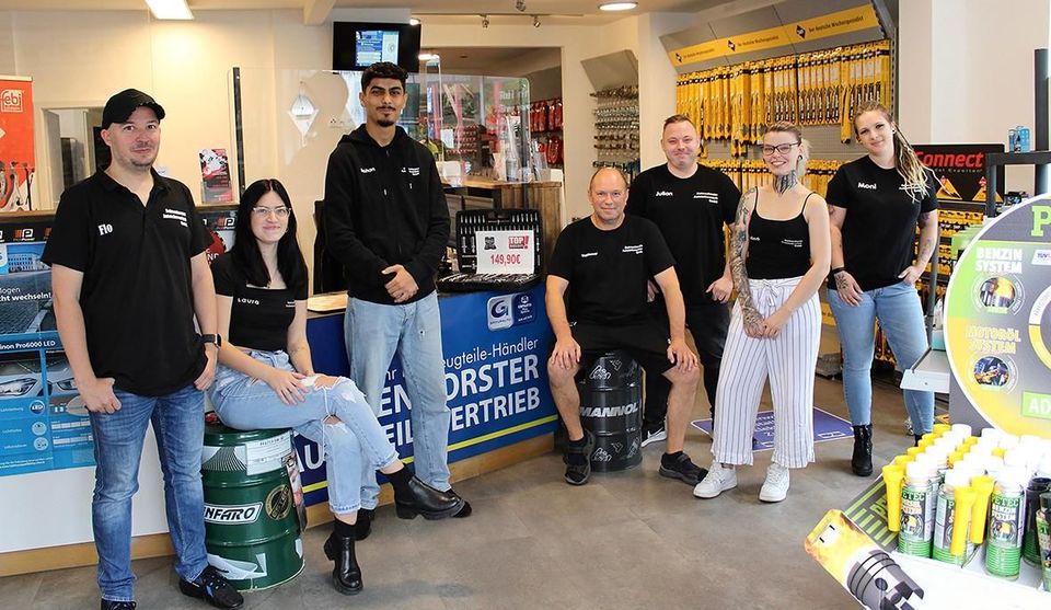 Eine Gruppe von Menschen posiert in einem Geschäft für ein Foto.