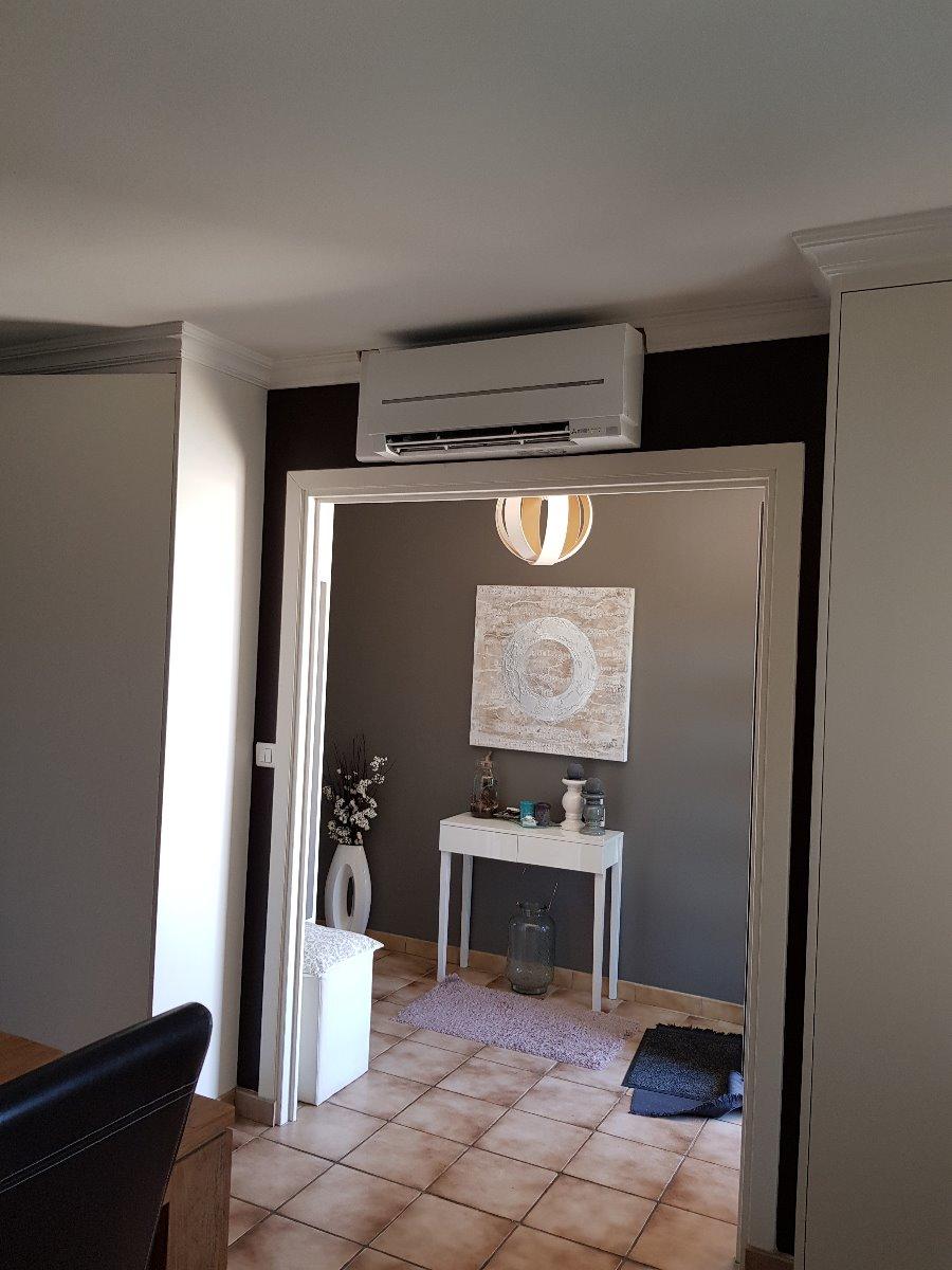 Climatisation murale en haut d'une ouverture pour porte dans un intérieur de particulier