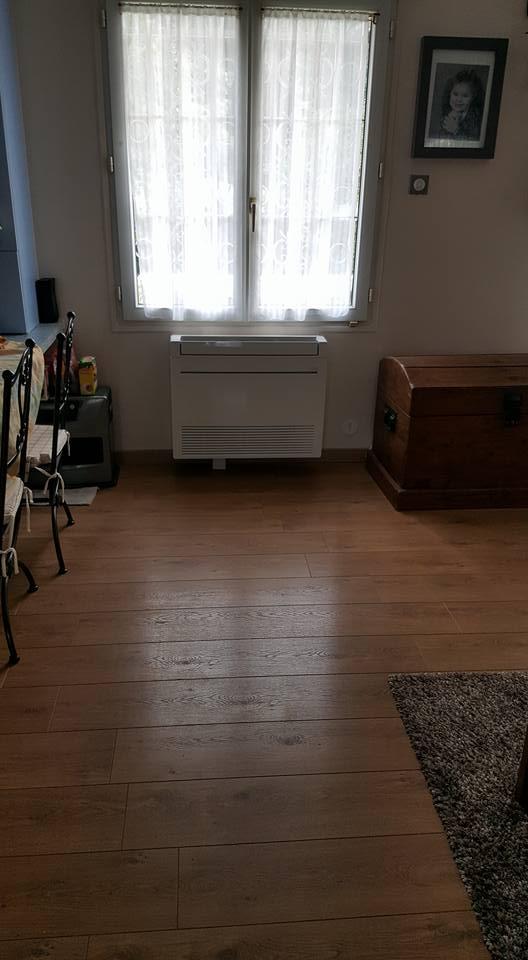 Système de climatisation installé en intérieur sous une fenêtre dans un intérieur au revêtement de sol en parquet