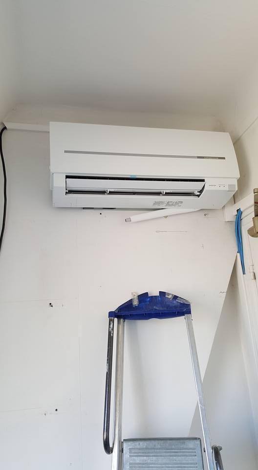 Climatisation murale en haut à gauche avec un escabeau posé contre le mur juste dessous