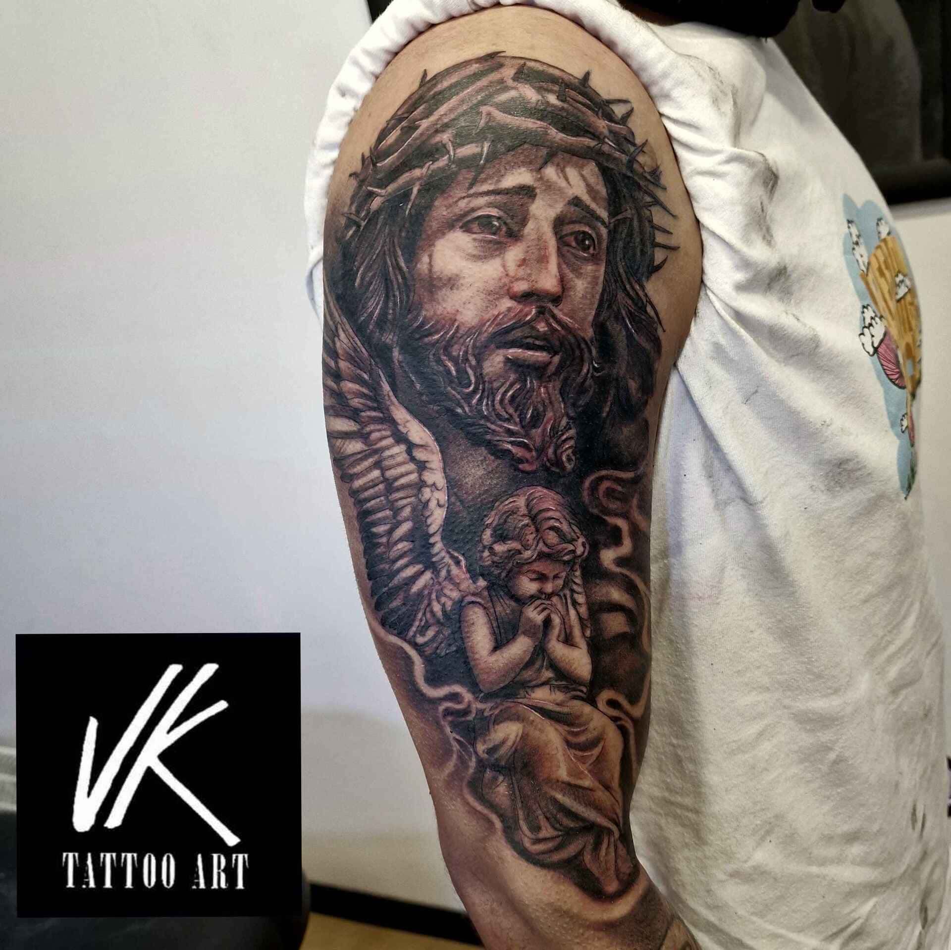 Un hombre tiene un tatuaje de Jesús en su brazo.