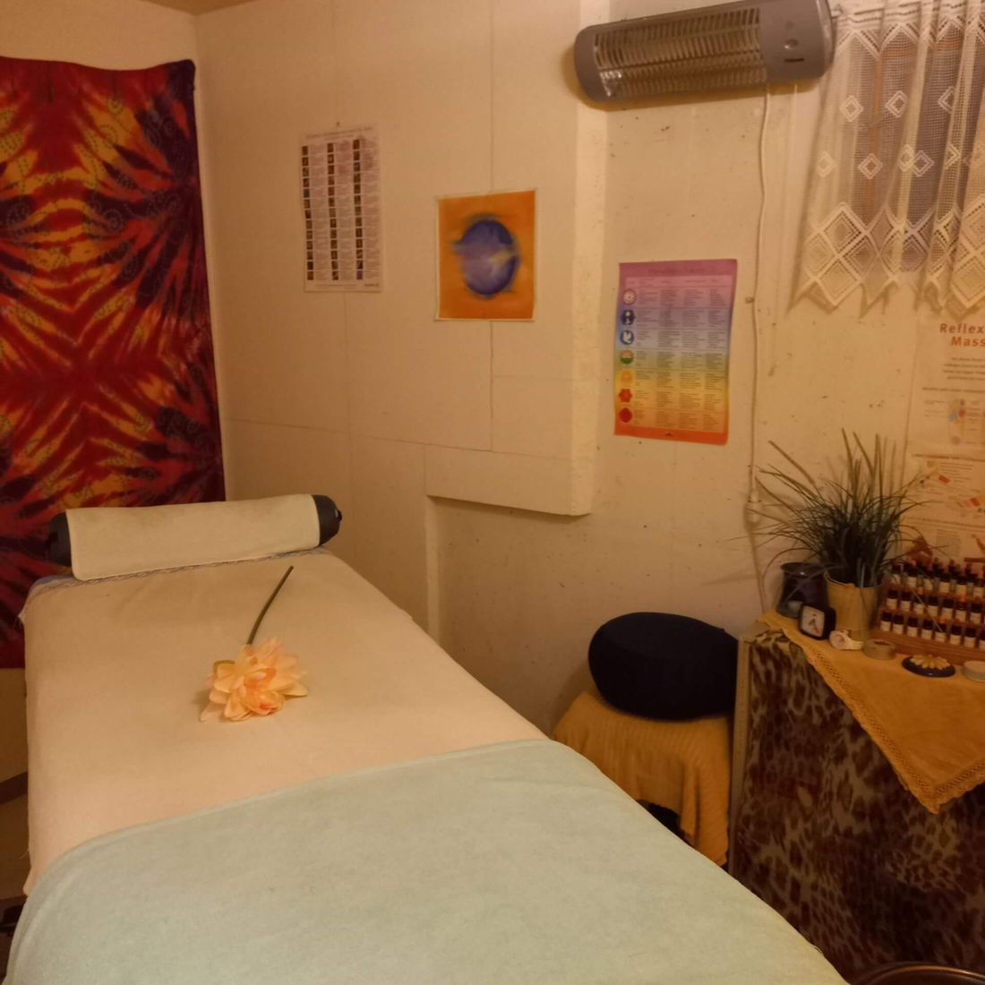 Ein Massagetisch mit einer Blume darauf in einem Raum