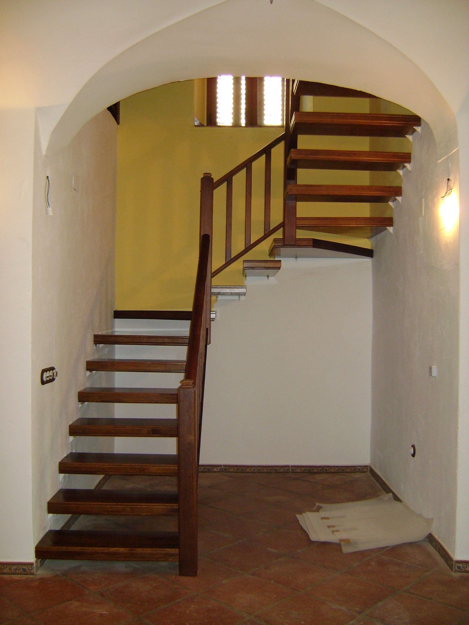 Una escalera de madera con una pared amarilla detrás.