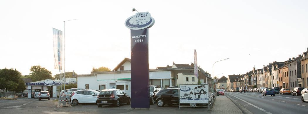 Vor einem Autohaus parken viele Autos