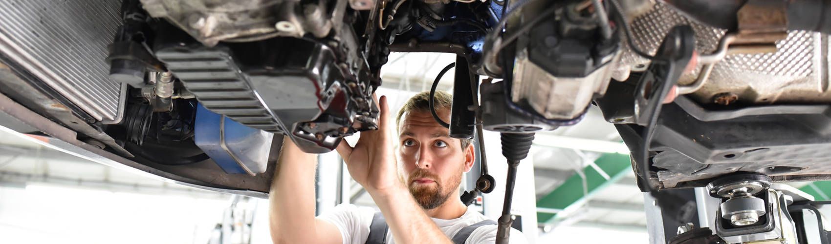 Ein Mann arbeitet an der Unterseite eines Autos.