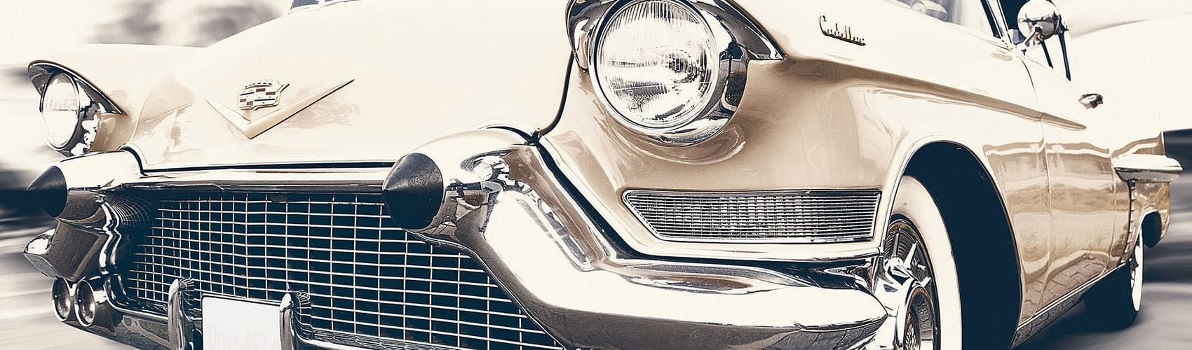 Ein weißer Oldtimer steht am Straßenrand